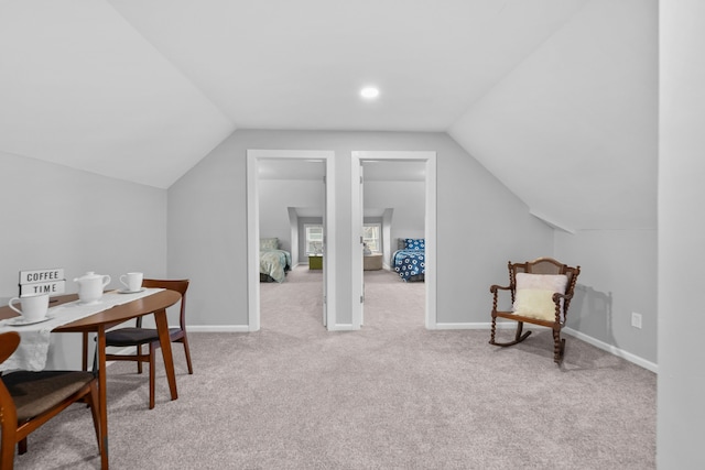 interior space with vaulted ceiling and light carpet