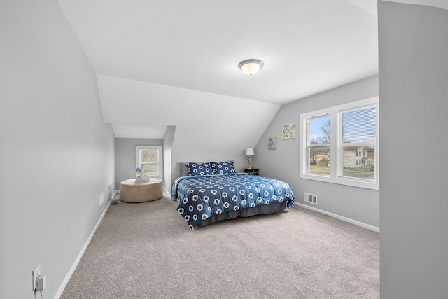 carpeted bedroom with vaulted ceiling and multiple windows