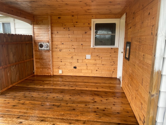 unfurnished room featuring wood ceiling, dark wood-type flooring, and wood walls