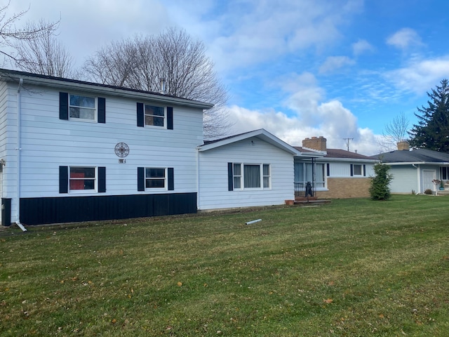 rear view of property with a lawn