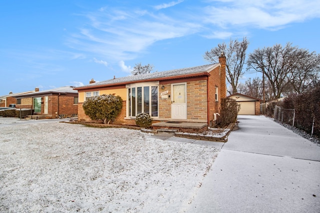 single story home with an outbuilding, brick siding, a chimney, and a detached garage