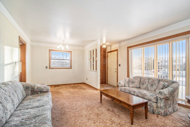 carpeted living room featuring plenty of natural light and a notable chandelier