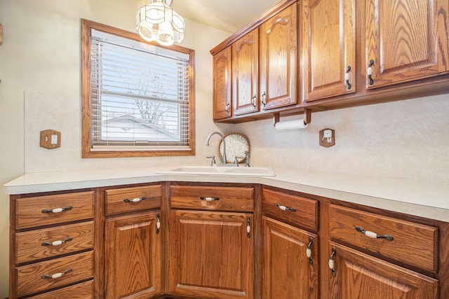 kitchen with brown cabinets, light countertops, and a sink