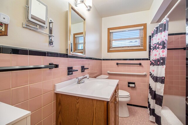 full bathroom featuring tile patterned flooring, tile walls, vanity, shower / bath combination with curtain, and toilet