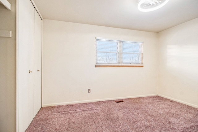 spare room featuring carpet flooring and baseboards