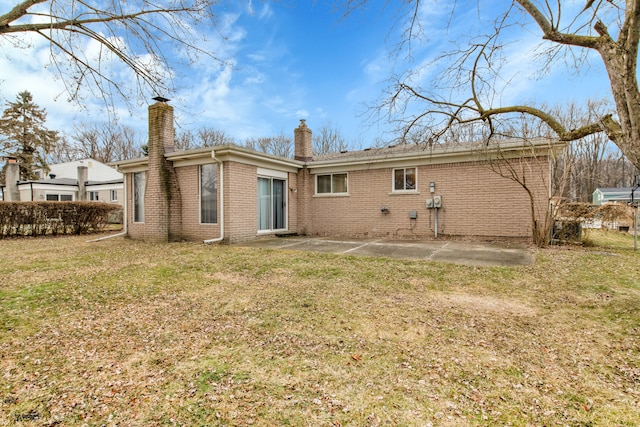 rear view of house featuring a yard and a patio