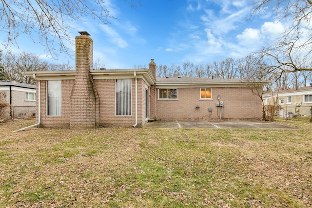 back of house featuring a patio and a lawn