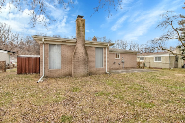 rear view of house featuring a patio and a yard