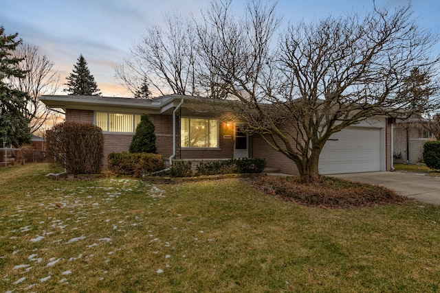 ranch-style house with a garage and a lawn