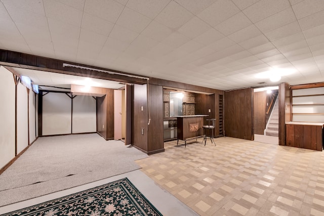 basement with bar area and wood walls