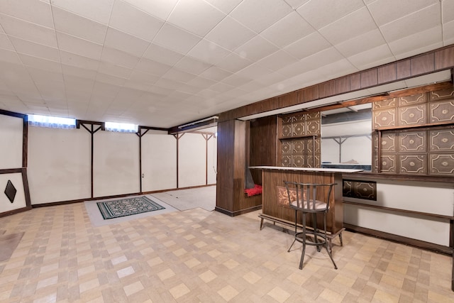 basement with bar area and wood walls