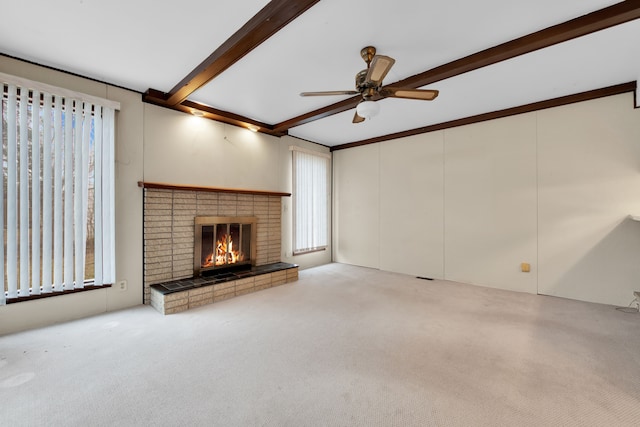 unfurnished living room featuring light carpet, beam ceiling, a fireplace, and a healthy amount of sunlight