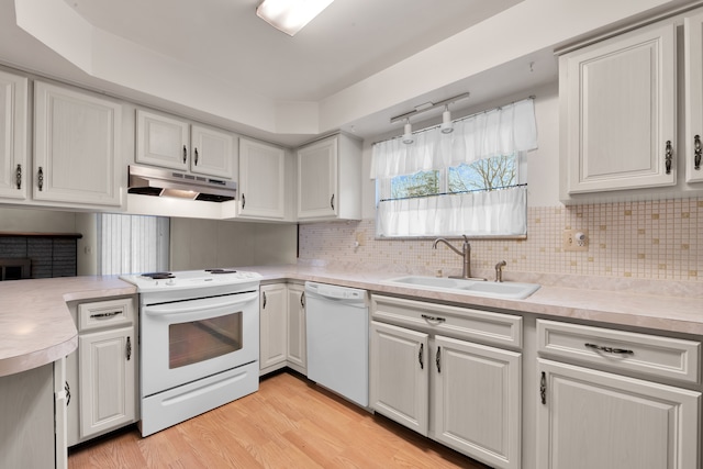 kitchen with white cabinetry, white appliances, and sink