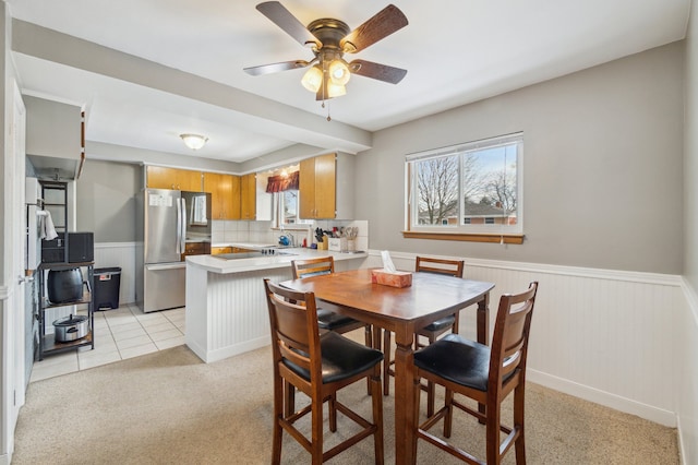 dining room with ceiling fan and light colored carpet