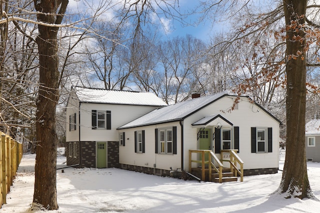 tri-level home featuring fence and a chimney