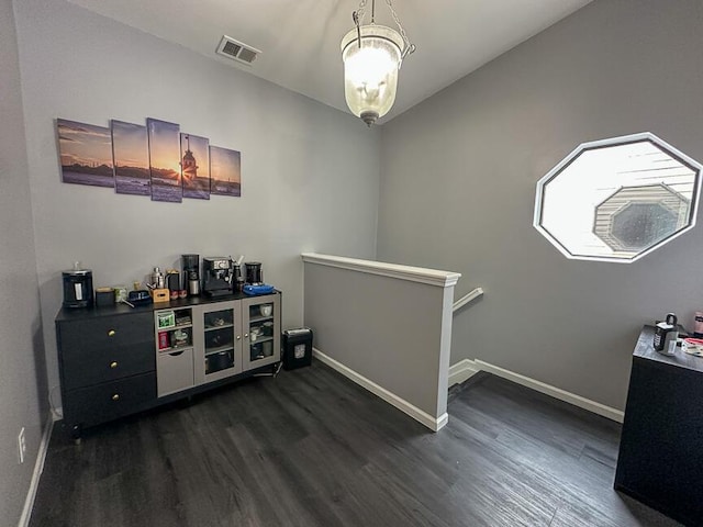 bar featuring visible vents, baseboards, and dark wood-style flooring