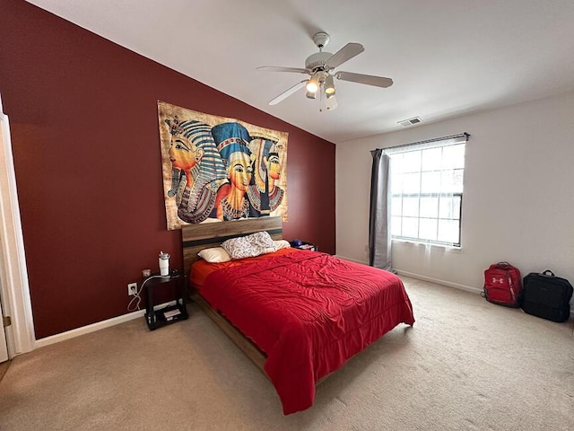 carpeted bedroom with visible vents, a ceiling fan, baseboards, and vaulted ceiling