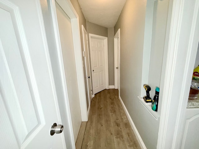 corridor with light hardwood / wood-style floors