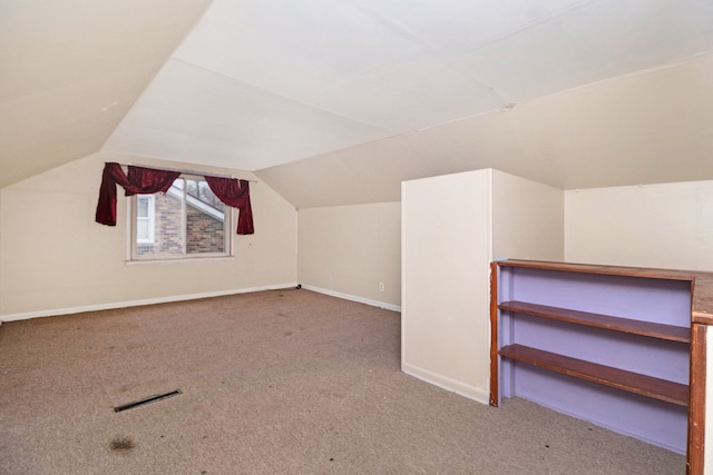 bonus room featuring lofted ceiling and light carpet