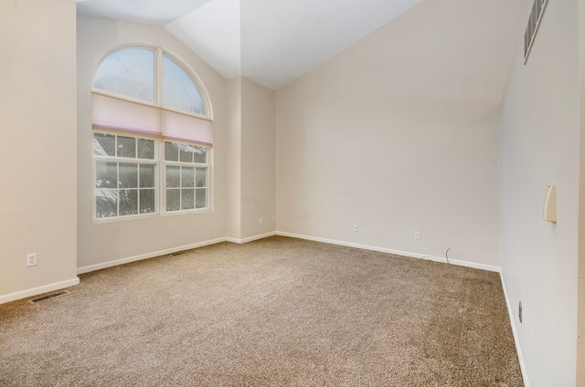 empty room featuring vaulted ceiling and carpet