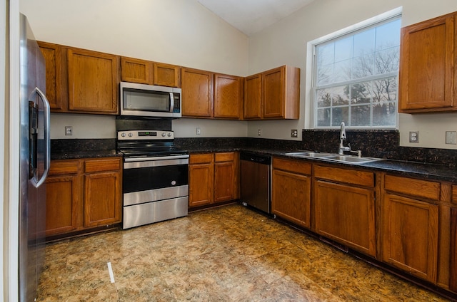 kitchen with lofted ceiling, stainless steel appliances, and sink