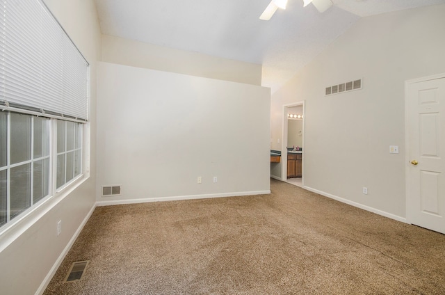 spare room featuring vaulted ceiling, ceiling fan, and carpet flooring