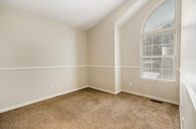 carpeted empty room with lofted ceiling