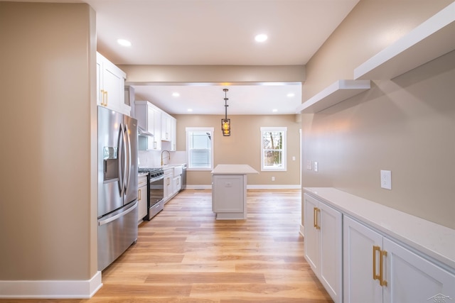 kitchen featuring pendant lighting, appliances with stainless steel finishes, a center island, tasteful backsplash, and white cabinets