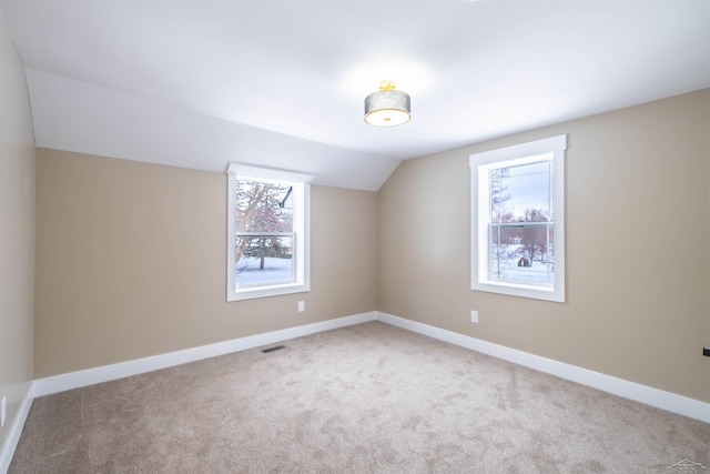 bonus room featuring carpet floors, a healthy amount of sunlight, and vaulted ceiling