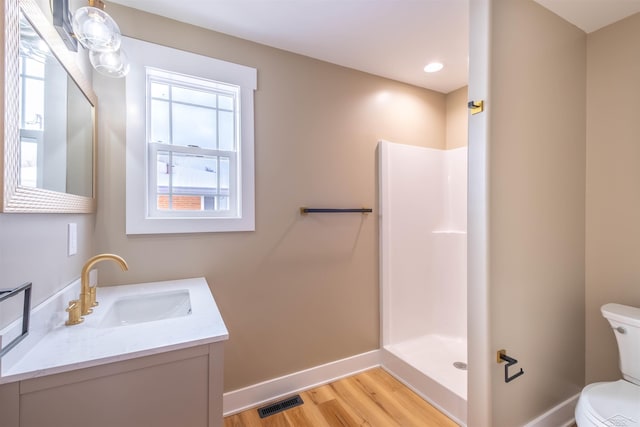 bathroom with walk in shower, wood-type flooring, vanity, and toilet