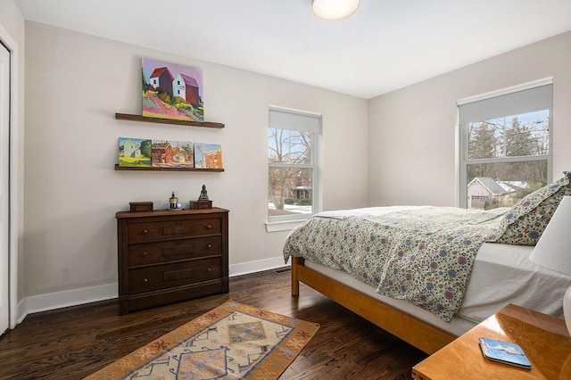 bedroom with multiple windows and dark hardwood / wood-style flooring