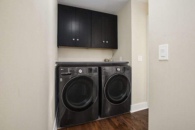 laundry room featuring cabinets, dark hardwood / wood-style flooring, and washer and clothes dryer