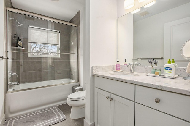 full bathroom with vanity, combined bath / shower with glass door, tile patterned floors, and toilet