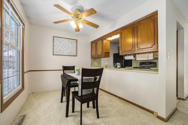 dining room featuring light colored carpet and ceiling fan