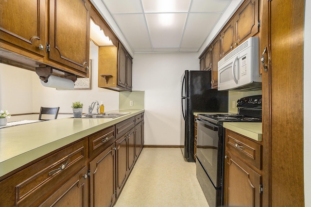 kitchen featuring sink, black electric range, and a drop ceiling