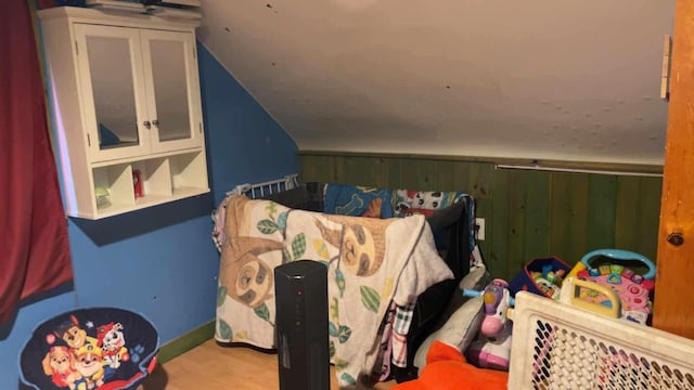 bedroom with wooden walls and vaulted ceiling