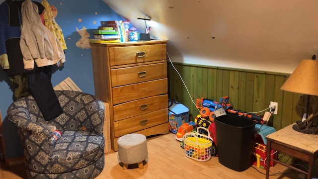 bedroom featuring light hardwood / wood-style flooring and wood walls