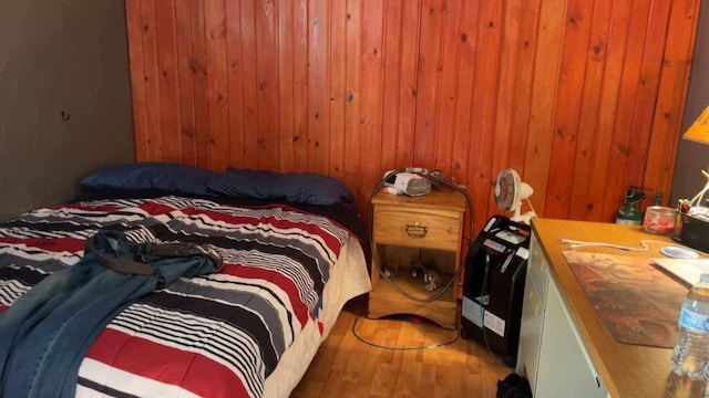 bedroom with wooden walls and hardwood / wood-style floors