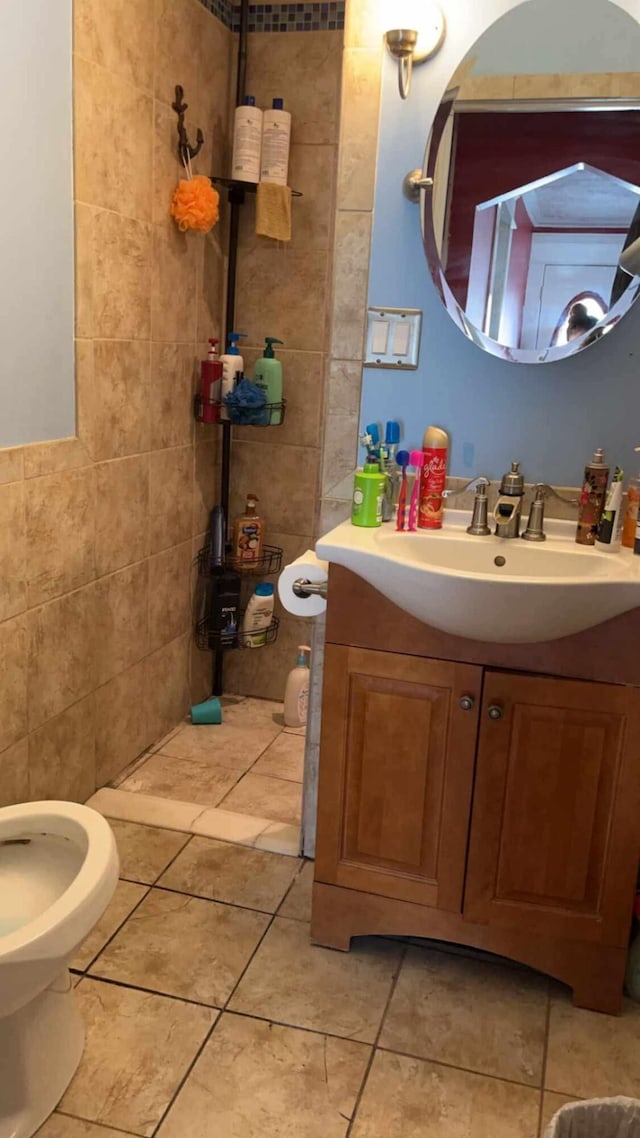 bathroom featuring vanity, tile patterned flooring, and tile walls