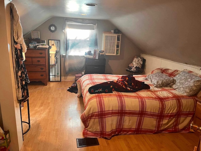 bedroom with lofted ceiling and light hardwood / wood-style flooring