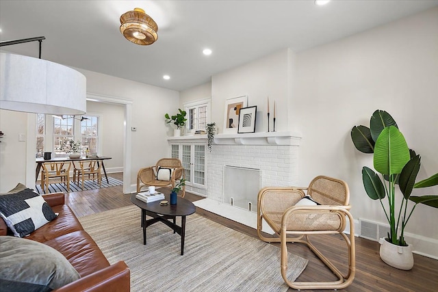 living room featuring hardwood / wood-style floors and a brick fireplace