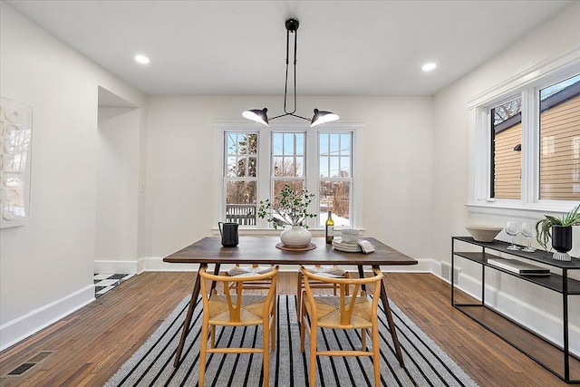 dining room featuring an inviting chandelier and dark wood-type flooring