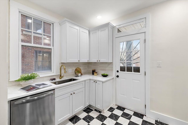 kitchen featuring dishwasher, sink, white cabinets, and decorative backsplash