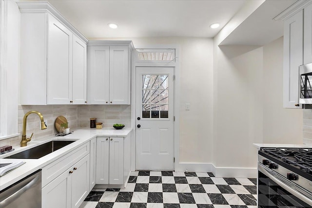 kitchen with stainless steel appliances, white cabinetry, sink, and tasteful backsplash