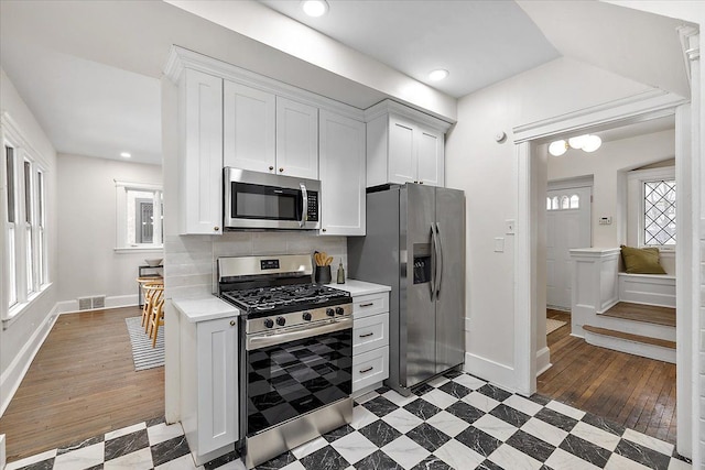 kitchen featuring plenty of natural light, appliances with stainless steel finishes, and white cabinets