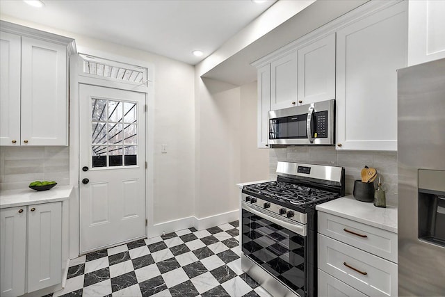 kitchen featuring tasteful backsplash, appliances with stainless steel finishes, and white cabinets