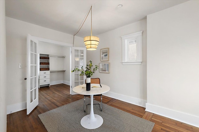 dining space with dark hardwood / wood-style floors and french doors