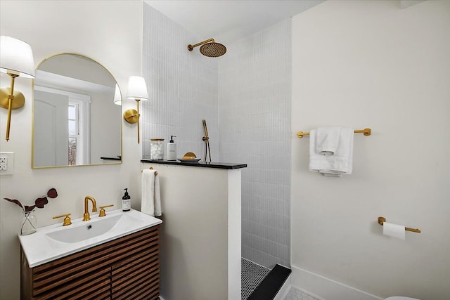 bathroom with vanity and a tile shower