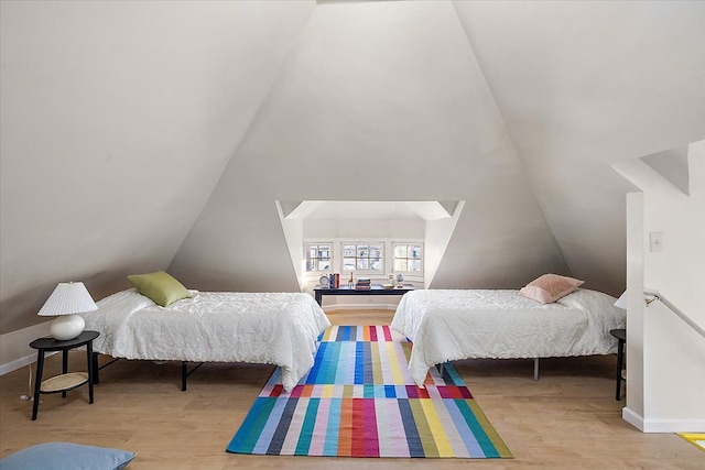 bedroom featuring lofted ceiling and light wood-type flooring