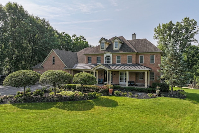 8557 Forestview Dr, Canton, MI 48187 - view of front of house featuring a chimney, a front yard, brick siding, a standing seam roof, and a porch